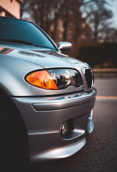 A grey E46 bmw 3 parked, front view.